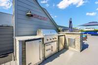 The rooftop features a custom outdoor kitchen complete with a dry sink, 2 Coyote refrigerators, and a Coyote gas grill.