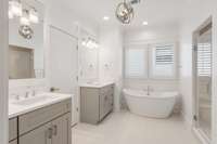 Primary bathroom with separate vanities for convenient sharing plus ample countertop and cabinet storage.