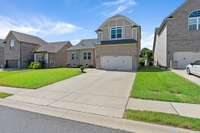 The wide driveway can accommodate your guests easily.  The two car garage has a built in work space for those projects around the house. It also has the capability to be equipped charge your electric car.