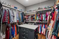 Primary Closet with an abundance of storage and custom shelving.