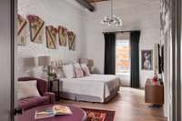 The primary bedroom of the residential unit, on the top floor, is a bright and charming space.