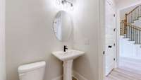 Elegant Powder Room with pedestal sink is conveniently located on the main floor