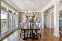 Beautiful formal dining room lined with windows showing off the amazing views and expansive front porch. Such an elegant setting for any dinner party!