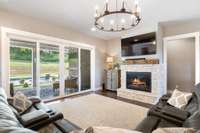 Living area looks out to patio and pool, and has gas fireplace and wagon wheel chandelier. What a great place to relax any season