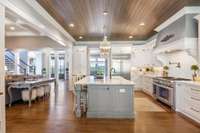 7" wide plank floor and stained shiplap ceiling frame the large well-appointed kitchen