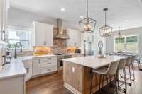 Look at this gorgeous sunny kitchen with quartz counters, wood floors, large island and stainless steel appliances!