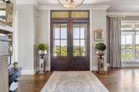 Warm yet stately foyer greets you from the impressive front porch