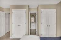 Double closets frame the door to the private ensuite bath.