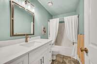 Quartz counters and tile floor in the guest room bath.