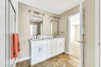 Quartz counter tops and tile floor in this shower bath.