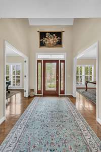 Lovely two-story entry with hardwood floors opens to the library/office and the dining room.