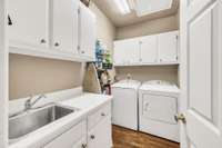 Just off the kitchen is a convenient laundry room with loads of cabinets and a built-in sink.  Washer and dryer may remain.