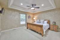 Do you have large furniture? Check out this MASSIVE owner's suite with a ceiling fan, a trey ceiling, and a relaxing view to wake up to every morning.