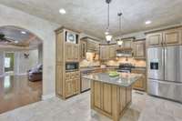 Custom cabinetry with granite countertops and a stylish island, illuminated by pendant lighting. There's even space for bar stools, perfect for grabbing a quick breakfast. All appliances are included and will remain.