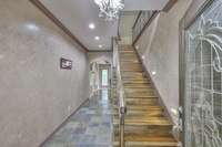 As you enter through the leaded glass door, you're welcomed by a slate-floored foyer and gleaming hardwood stairs, accented with elegant iron spindle work.