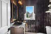 Half bath with custom vanity and light fixtures.