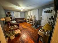 Spacious living room with the original hardwood floors.  This home has a suprising amount of space!