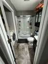 Large bathroom with shower/tub combo and laundry closet.  Washer and dryer remain.