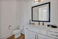 Main level half bath. *Photo is of model home, actual features and finishes may vary.