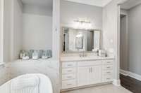 Dual vanities with drawer stacks in each, quartz counter tops, and a private water closet finish out the space.