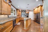 Your chef's kitchen awaits with custom cabinetry, stainless steel appliances, gas stove, granite countertops, and tile backsplash.