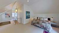 The bedroom area upstairs is a loft-style open area with doors leading outside to a porch & stairs.