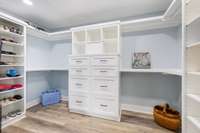 Custom wooden shelving closet design with a safe for storing valuables built in.