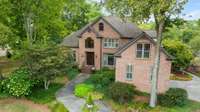 This home looks straight out of a storybook with lush landscaping, mature trees and winding path to the front door. (Please note security cameras do not convey)