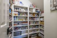 Spacious walk in pantry with built in shelving.