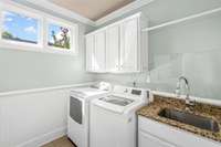 Laundry on main, featuring mud sink and countertops for working space