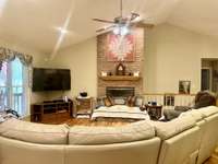 Living Room with gas fireplace on main level flowing from Dining Room and Kitchen Bar Top area. Vaulted ceilings and open walls allow ample lighting into every room