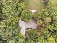 Drone footage of home with lots of mature trees and wooded acreage