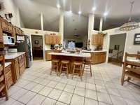 Large Kitchen with custom oak cabinets with large island; Open walls and recessed lighting; Flows into Laundry Room/Storage Room; Kitchen overlooks Living Room/Dining Room with gas log fireplace