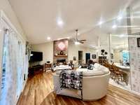 Living Room overlooking the covered deck with lots of natural light thru the windows and double doors. Recessed lighting in vaulted ceilings bring the room to life