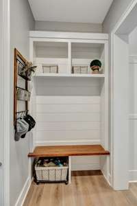 Cozy mudroom with built-in storage, wooden bench, and shelving, offering practical organization and convenience for daily essentials.