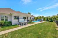 Backyard paradise with a pool, stone waterfall, water slide, spacious patio, and lounging area, perfect for enjoying the outdoors in style.