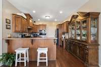 The spacious and functional kitchen offering double ovens, ample wooden cabinets, coffee station, and direct access to the Butler's Pantry that offers built-in shelving and additional prep area.