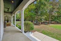 Covered back porch overlooks the park like backyard and playset that remains.