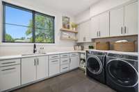 The downstairs laundry is huge and has plenty of storage space, room for hanging clothes, and counter space.