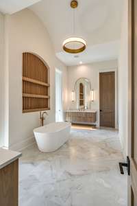 Luxurious Primary Bath with double floating vanities, spa-like shower, soaking tub and dual wardrobe closets.