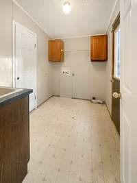 The laundry room is off the den, and has a door leading out to the side deck. There's a pantry, deep sink, and washer/dryer hookups.