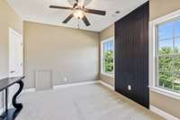 All of the secondary bedrooms are spacious and this one features a ceiling fan and accent wall.