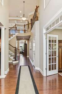 The 2-story entryway is impressive with the curved staircase, office to the right, and living room to the left.