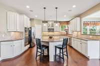 The kitchen features an island, perfect for food preparation, space for bar stools and pendant lighting.