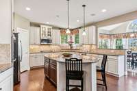 The kitchen features a tile backsplash, granite countertops, and corner windows above the sink!