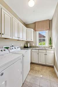 Wow!  What an amazing laundry room!  Look at the all the space this room offers.  Plus, a built-in sink with a window above.