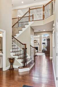 The staircase is located just to the left of the entry. Iron spindles and wooden treads make this staircase stunning.