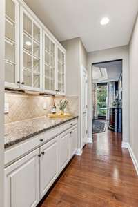 The butler's pantry is located between the formal dining room and the kitchen.  The glass front cabinets are perfect for showing off your dinnerware.