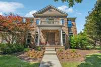 The grand entrance of the home is accented with lush landscaping.