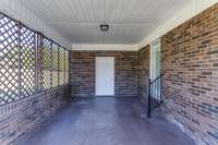 The carport has ornamental wooden grates for privacy.